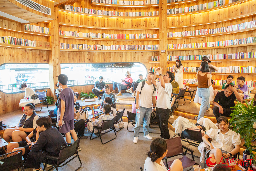 10月7日，浙江省溫州市蒼南縣金鄉(xiāng)鎮(zhèn)石砰碼頭，由擁有數(shù)十年歷史的老油庫(kù)改造而成的咖啡館內(nèi)，游客們喝咖啡、品書(shū)香、賞海景，盡享假日休閑時(shí)光。人民網(wǎng)記者 葉賓得攝