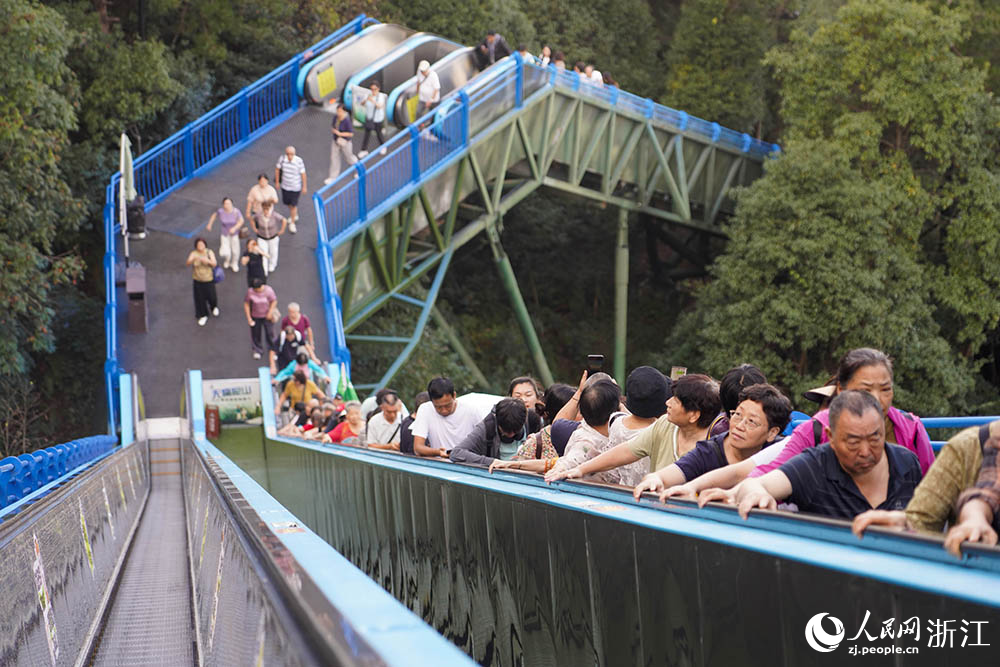 10月15日，浙江省臺(tái)州市仙居縣神仙居景區(qū)，游客通過(guò)自動(dòng)扶梯輕松爬山。人民網(wǎng) 章勇濤攝