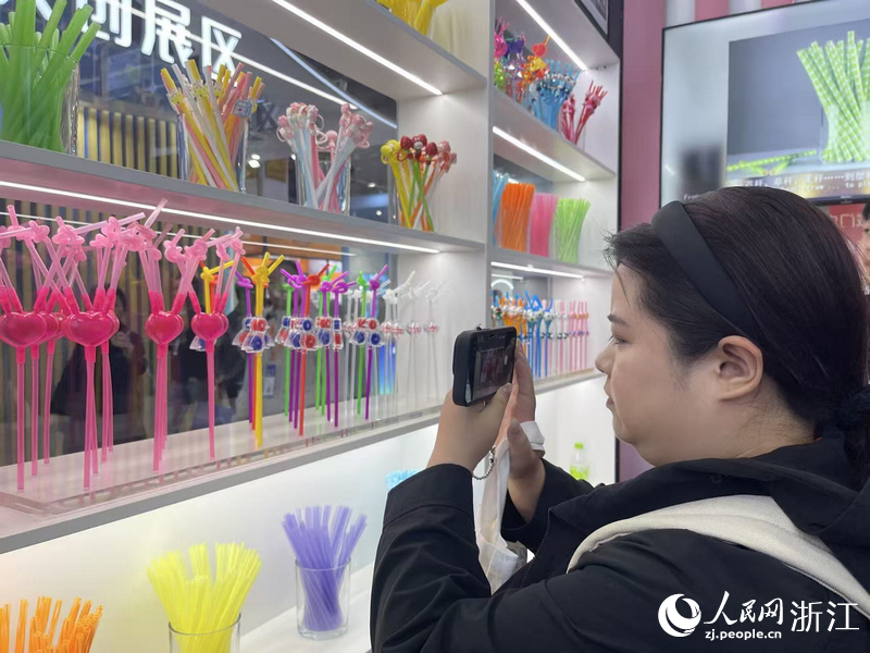 一名客商正在拍攝創(chuàng)意吸管產(chǎn)品。人民網(wǎng)記者 王麗瑋攝