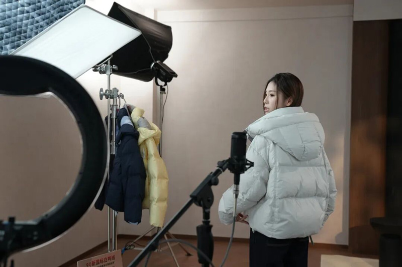 主播正在展示一款羽絨服。萬象街道供圖
