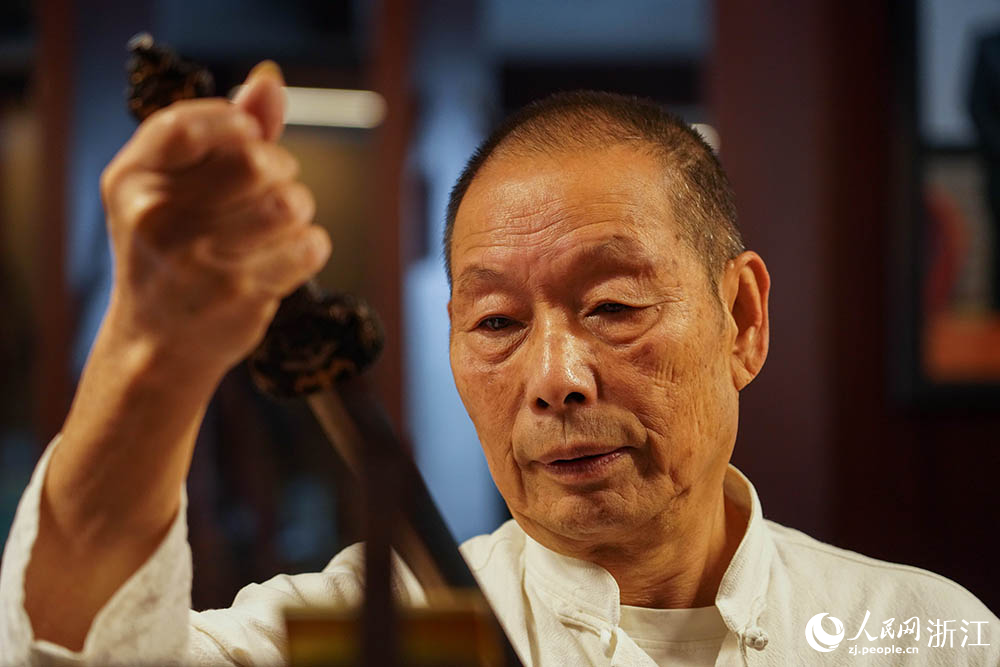 在浙江省龍泉市沈廣隆劍鋪，沈新培在查看龍泉寶劍成品。人民網(wǎng) 章勇濤攝