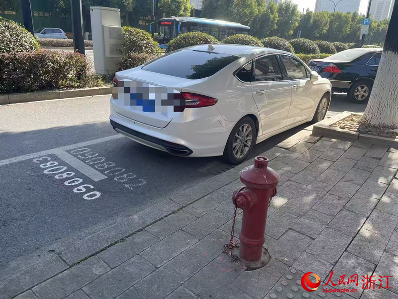 11月29日12時記者目擊，余杭區(qū)閑富北路上，一收費停車位緊鄰消防栓。人民網(wǎng)記者 王麗瑋攝