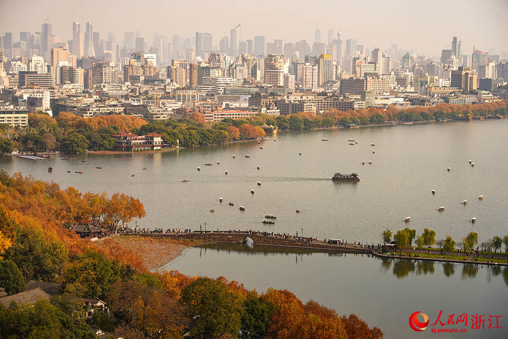 城市天際線與湖光山色相映成趣，市民游客徜徉其間。人民網 章勇濤攝